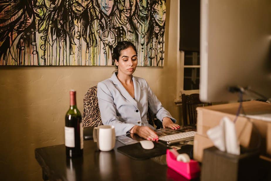 A Woman Sitting on a Chair while Looking at the Table Preparing herself to the online course