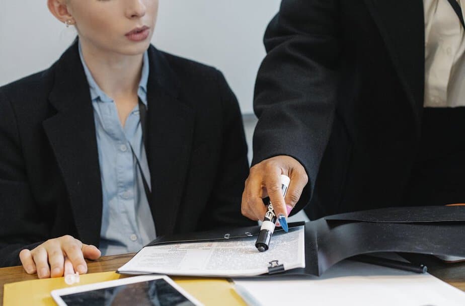 Crop colleagues in formal wear checking documents