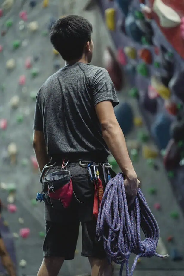 Back view of a climber with gear, ready for an indoor climbing session.