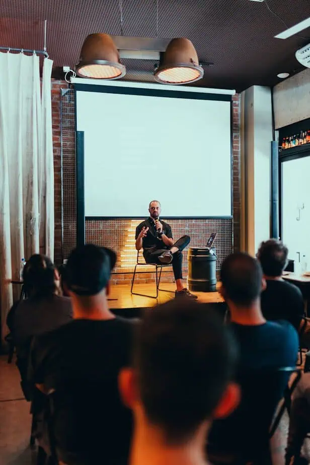 Photo by Matheus Bertelli Speaker engages an audience during a business seminar in a modern conference room.