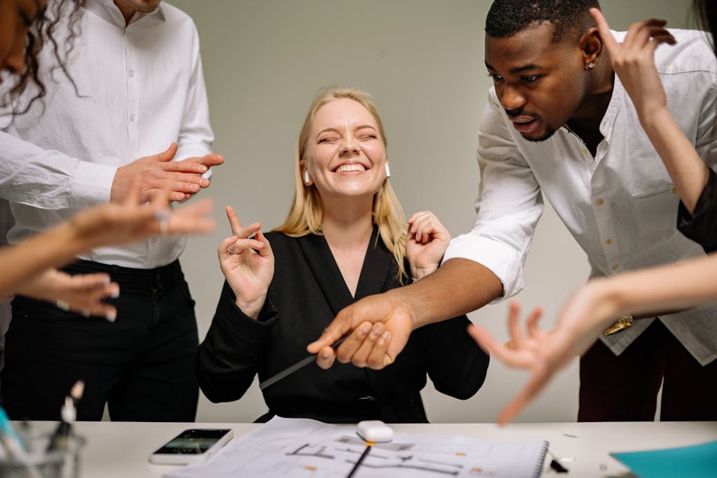A diverse team engaging in a lively office discussion, showcasing teamwork and collaboration.