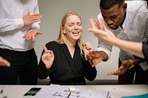 Diverse business team engaging in a lively office discussion with expressive gestures and focused collaboration.