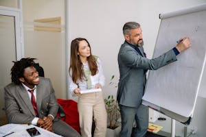 Diverse group of business professionals engaging in an office presentation, fostering teamwork and collaboration.