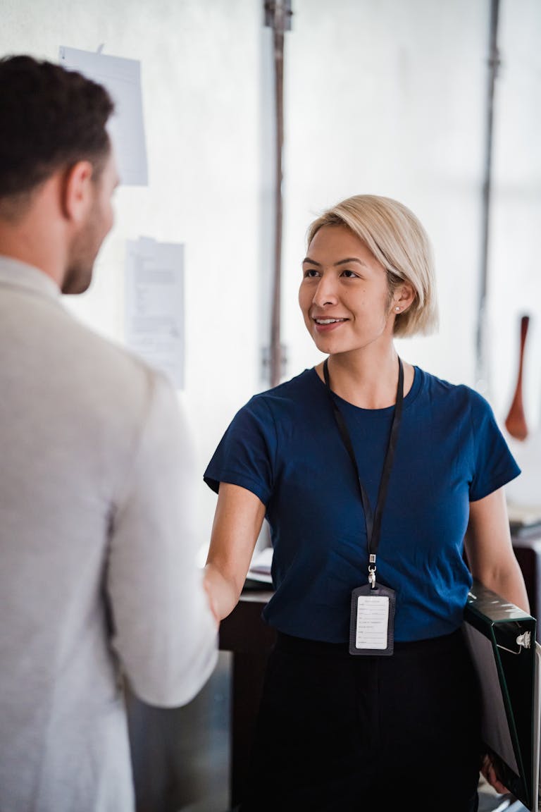 Friendly handshake between business professionals in an office environment, emphasizing teamwork.