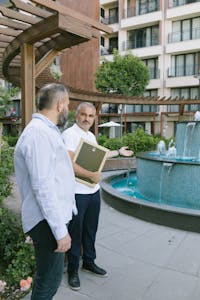 Two men engaging in conversation by a fountain in Istanbul, outdoors.