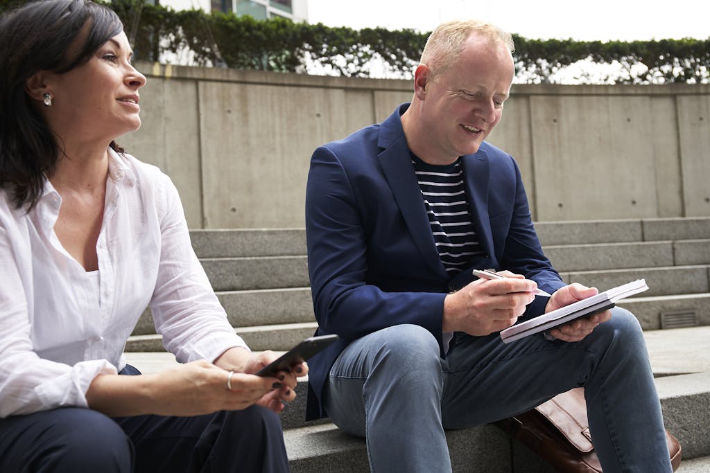 Photo by The Coach Space A man and woman engage in a work-related discussion outdoors in London.