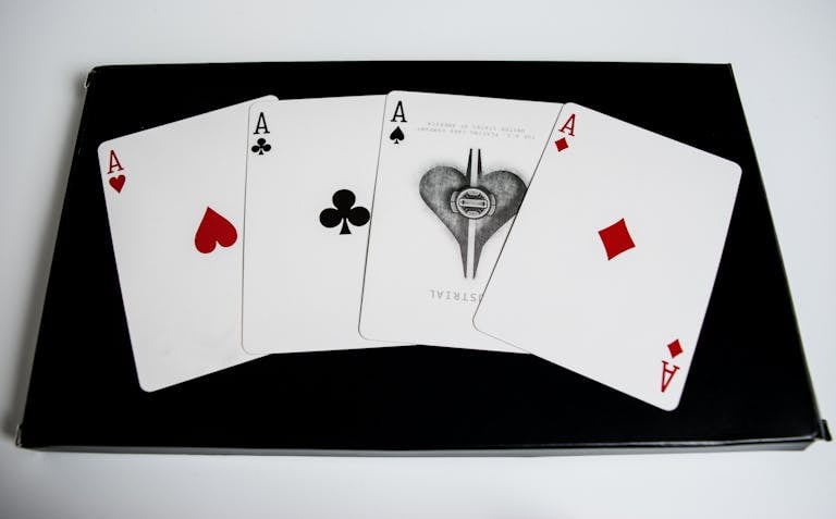 High-quality image of four aces from a deck of playing cards on a black surface.