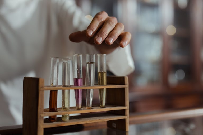 Close-up of a hand handling test tubes in a laboratory showcasing scientific research.