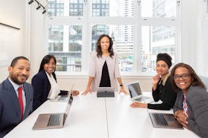Multicultural team collaborating in boardroom with laptops, showcasing teamwork and diversity.
